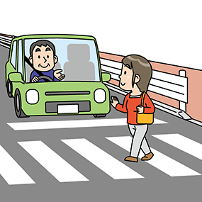 横断歩道の手前で止まる車の画像