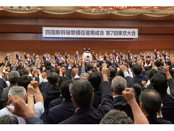 知事がみんなと右手をあげている