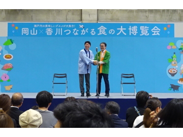 知事がステージに立っている