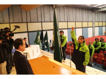 知事がステージで選手の表明を聞いている